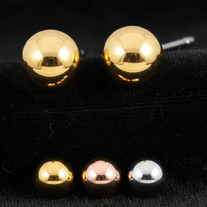 Gold, rose gold, and silver round stud earrings on a white background