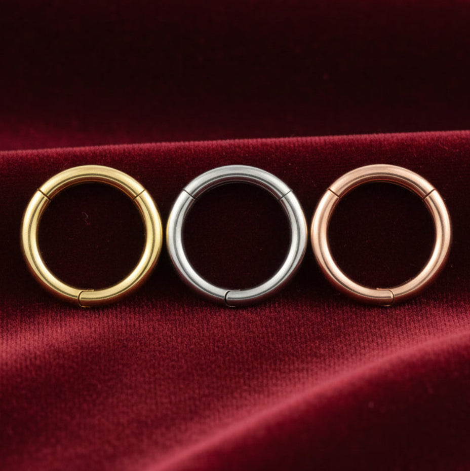 Three circular rings in gold, silver, and rose gold on a white background