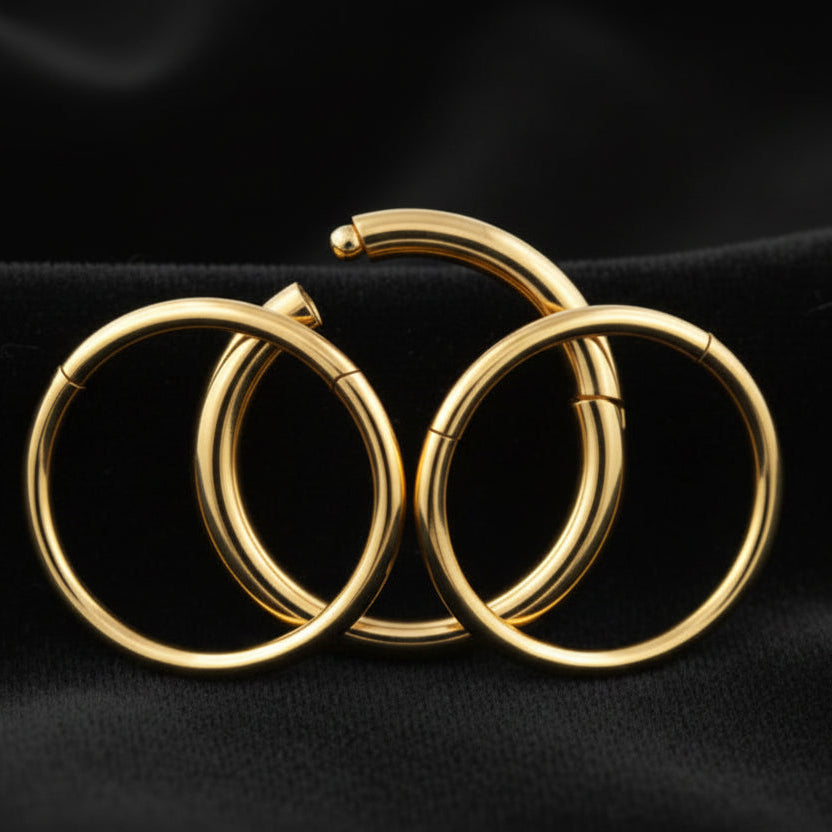 Three gold hoop earrings on a white background
