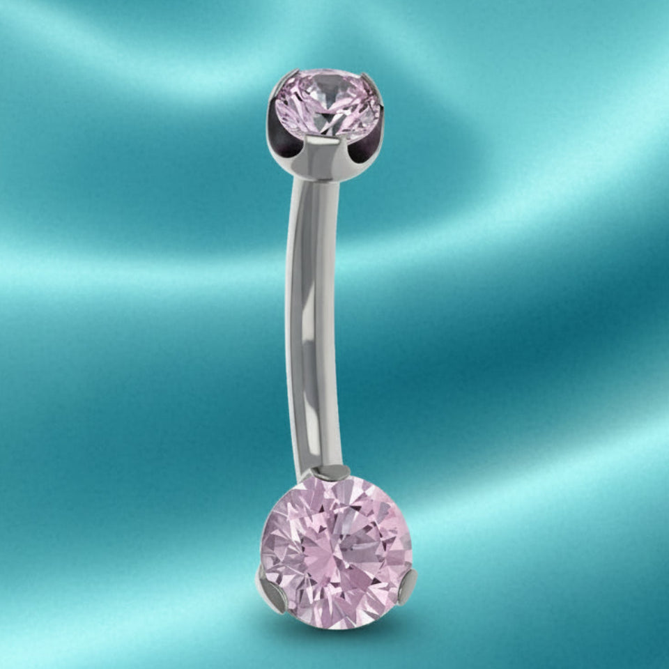Belly button ring with pink gemstones on a white background