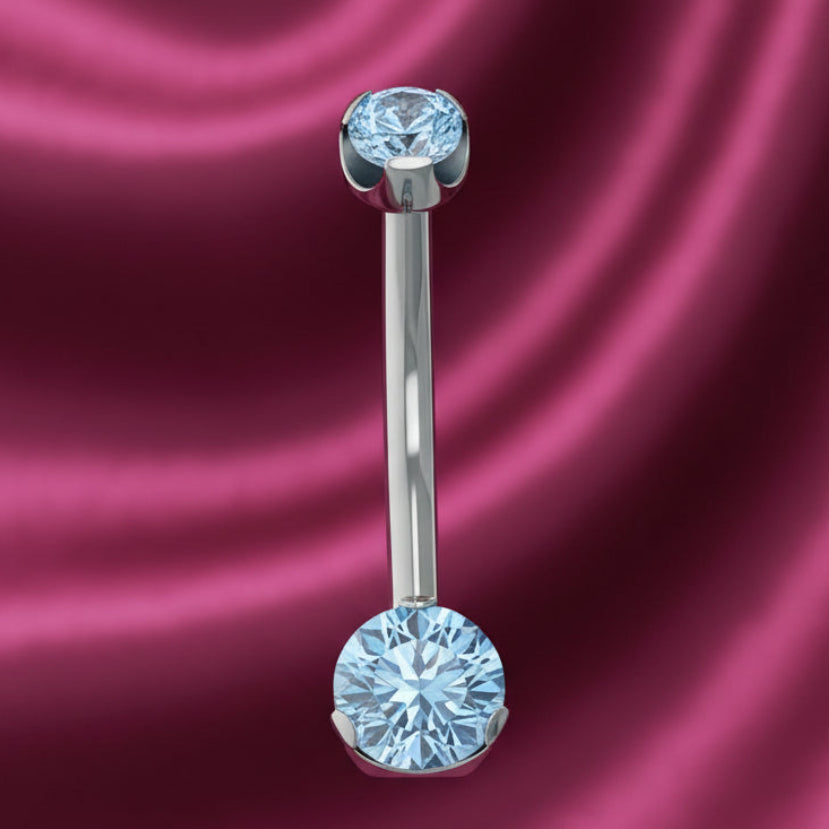 Belly button ring with blue gemstones on a white background