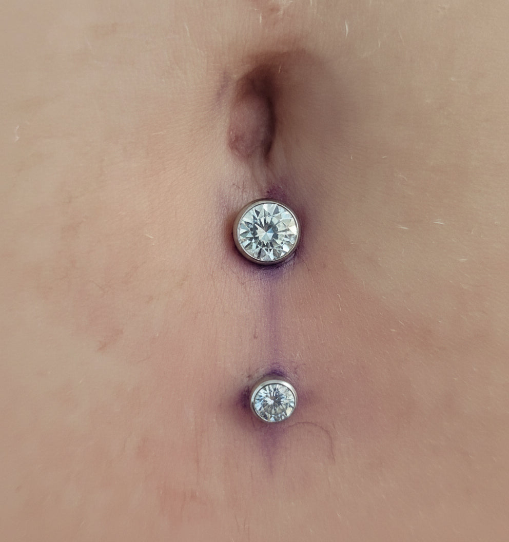 Close-up of a person's ear with two diamond-studded earrings.