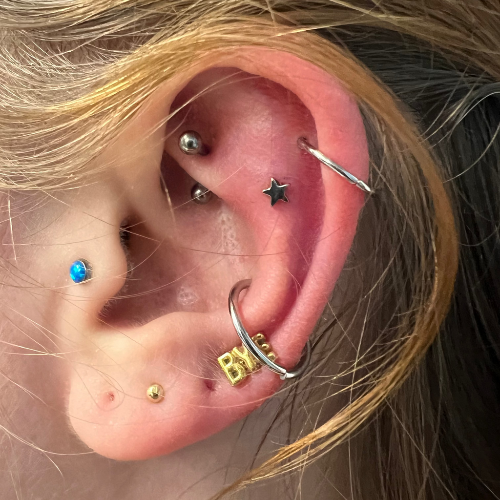 Close-up of an ear with multiple piercings and earrings.