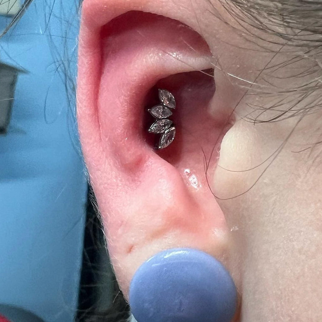 Close-up of an ear with a blue earring.