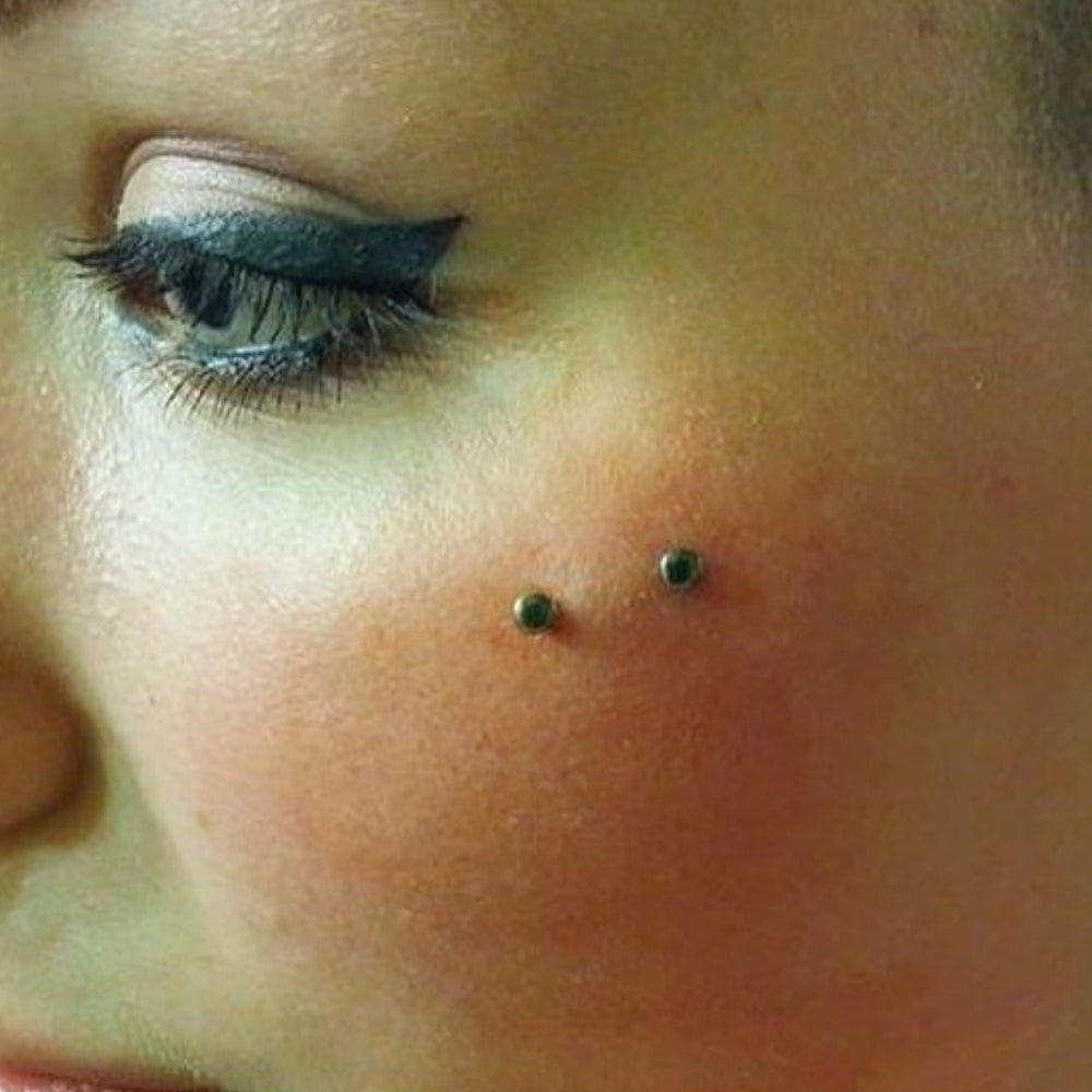Close-up of a person with a nose ring and colorful earring.