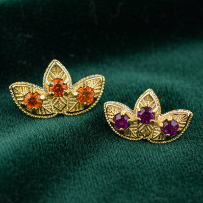 Pair of gold earrings with gemstones on a white background