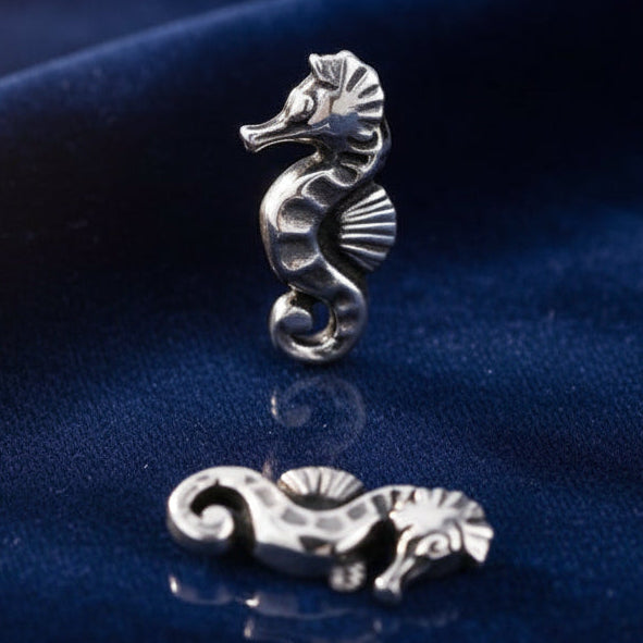 Silver seahorse-shaped earring on a white background