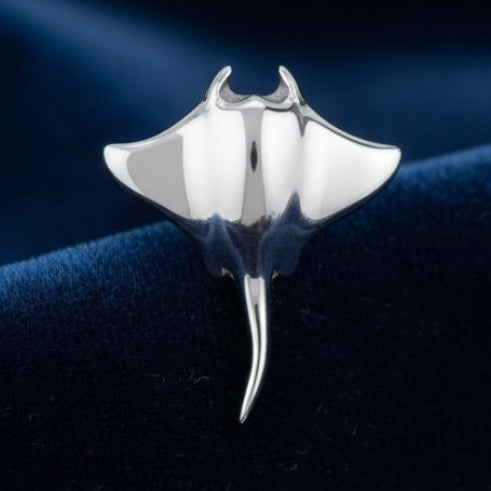 Silver stingray-shaped earring on a white background.