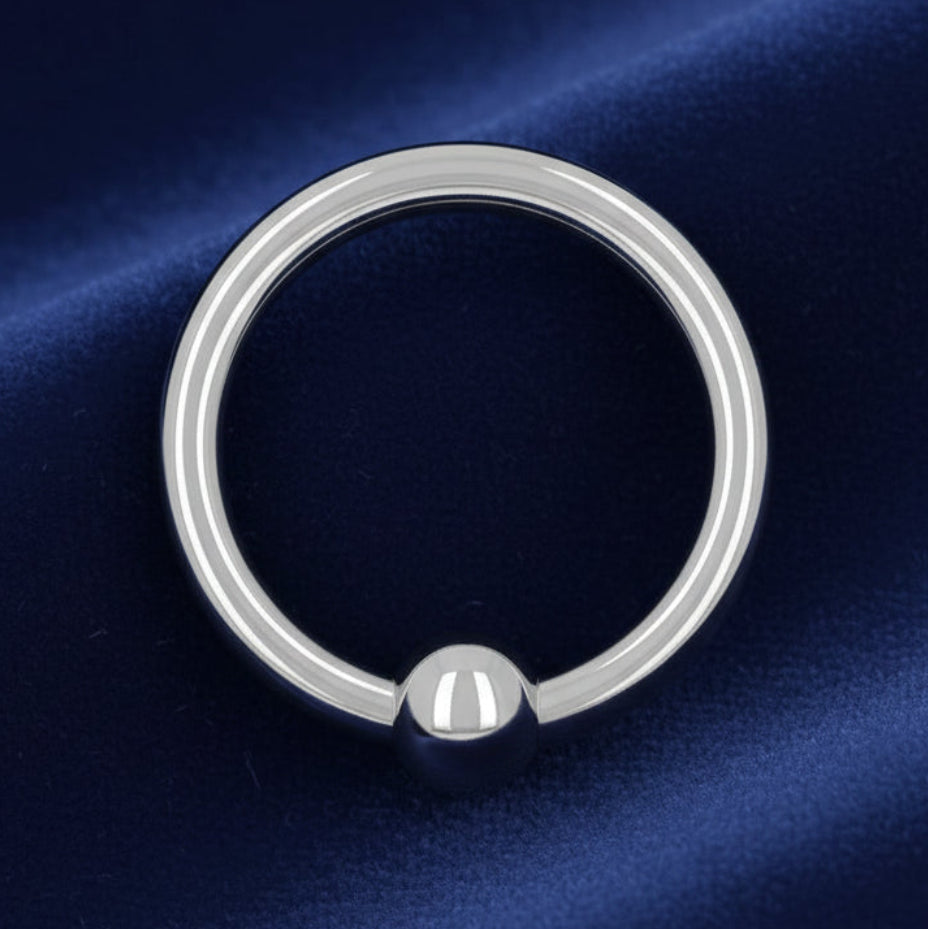 Silver ring with a round pendant on a white background