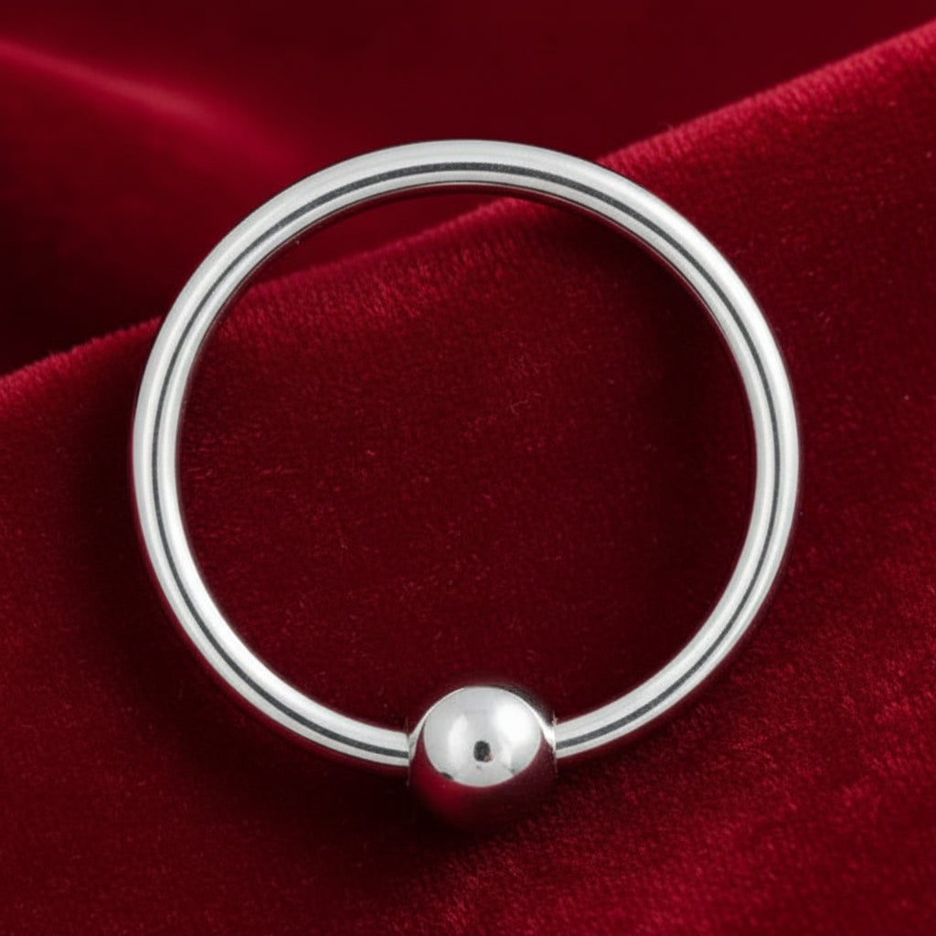 Silver ring with a round pendant on a white background