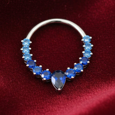 Sapphire blue beaded hoop earring on a textured beige background with 'Sapphire Blue' text.