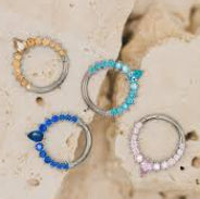 Set of circular earrings with gemstones on a textured beige surface