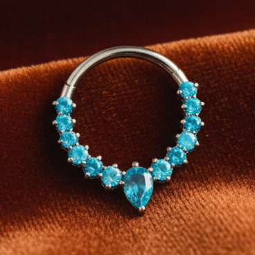 Silver ring with blue gemstones on a beige stone background