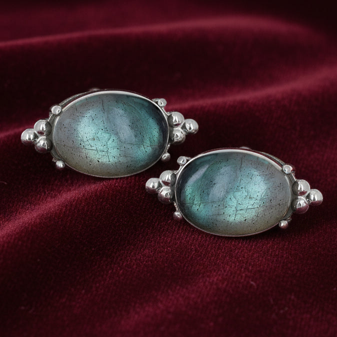 Pair of earrings with green gemstones on a white background