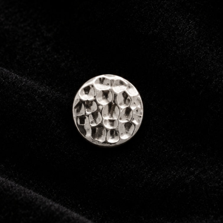 A single round silver-toned metal bead with a textured, hammered surface, shown on a plain white background.