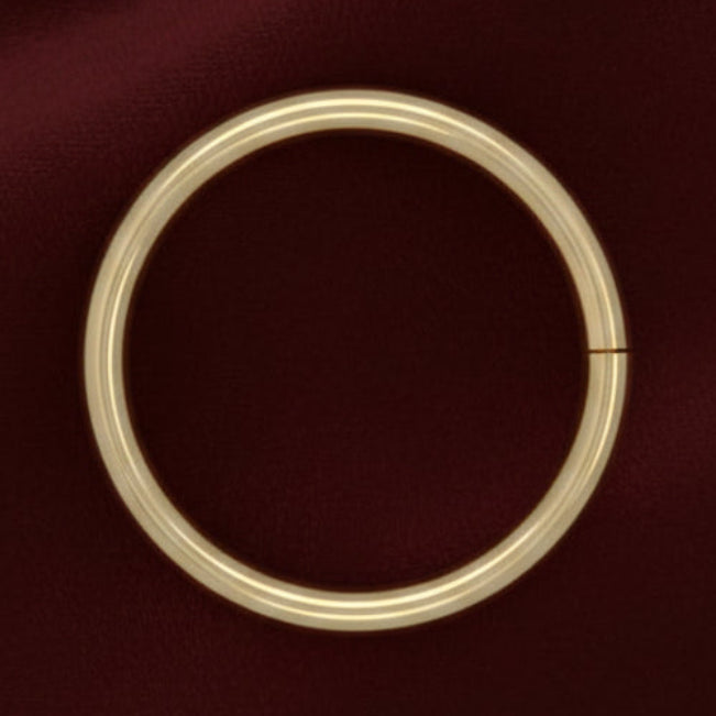 Gold ring on a maroon fabric background