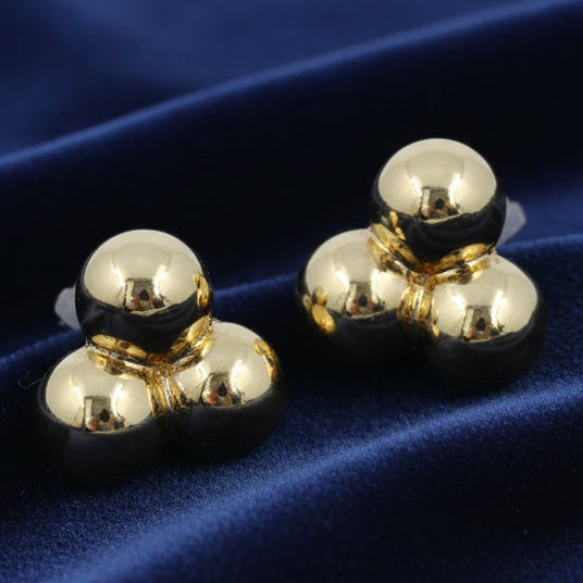 Gold ball stud earrings on a white background
