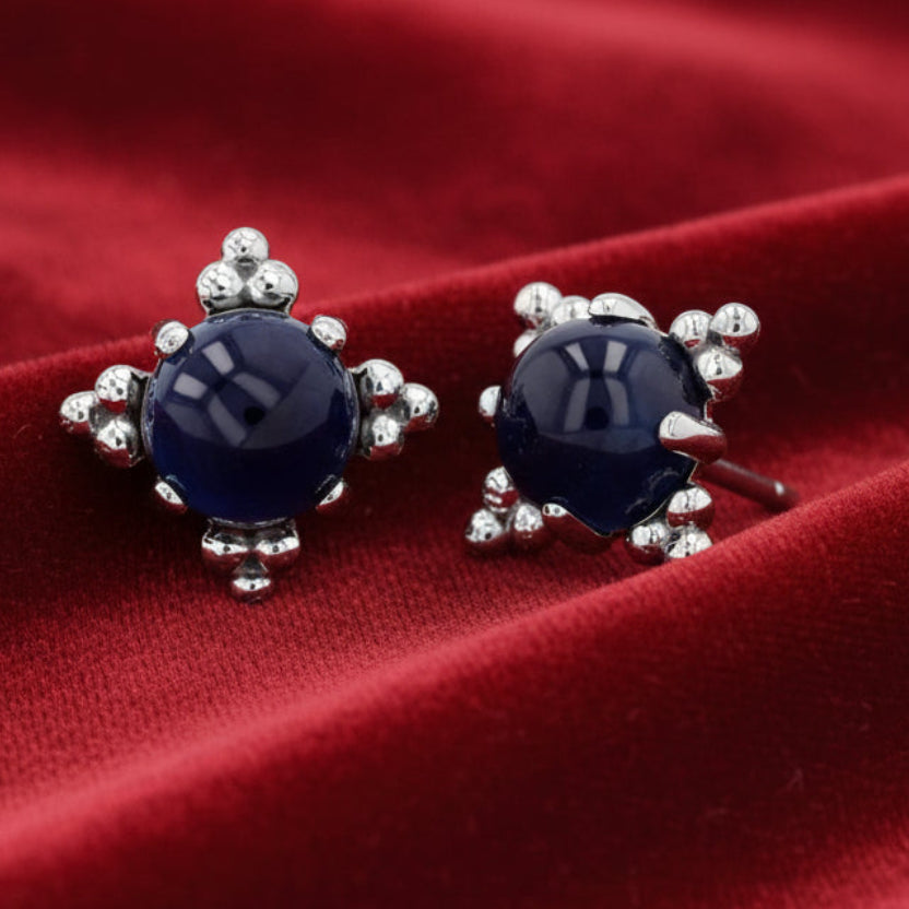 Pair of blue gemstone earrings with silver accents on a white background